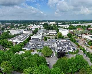 Blick auf ein Industriegebiet mit vielen Bäumen und Gebäuden.